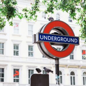 photo of red and black Underground street signage with two birds on top