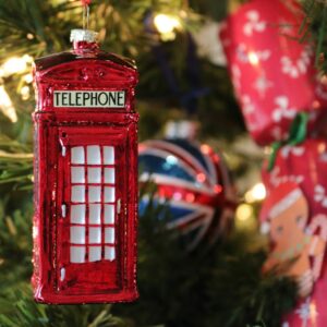 a red phone booth ornament hanging from a christmas tree